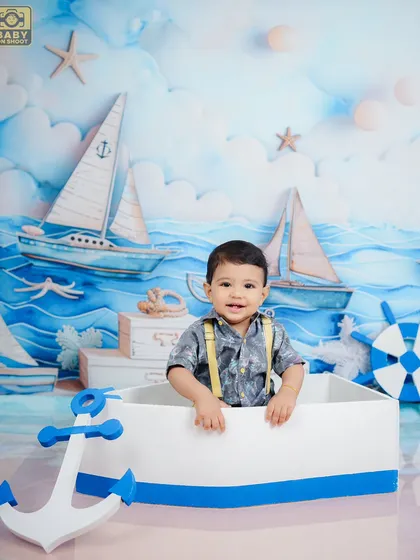 Ahoy, little sailor. This nautical-themed shoot features a mini boat, anchor, and a sea-faring backdrop for an adventurous portrait.