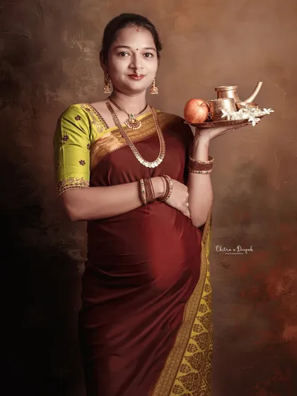 A graceful portrait of a mom-to-be in a traditional saree, holding a platter of offerings, symbolizing prosperity and well-being.