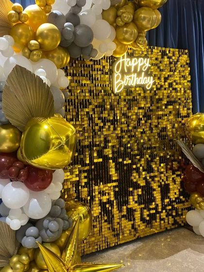 A close-up of the balloon arch with dried palm leaves, adding a trendy bohemian touch to the birthday decor.