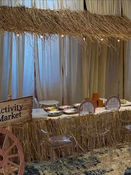 The rustic "Activity Market" stall, complete with a thatched roof and string lights, ready for a day of creative fun.
