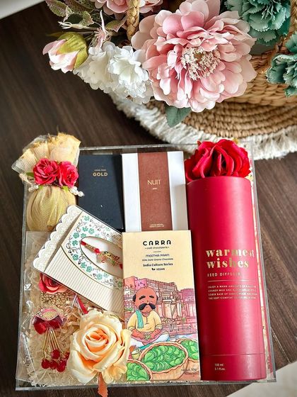 An elegant acrylic box Rakhi hamper for your Bhaiya and Bhabhi. It contains a reed diffuser, matching Zara mini perfumes, a decorative coconut, and a lumba-rakhi set.