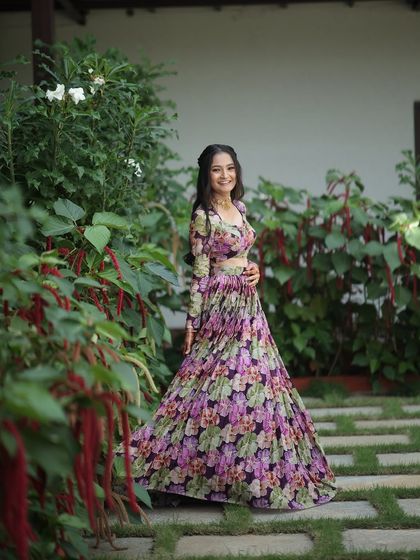 A dreamy, ethereal lehenga for the modern woman. This piece features a flowing, pleated skirt with a soft floral print, paired with a matching full-sleeve blouse for a look of effortless elegance.