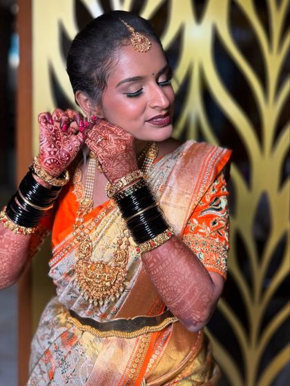 The final touches make all the difference. Here, my bride adjusts her earring, showing off her beautiful henna and the rich colors of her traditional wedding attire.