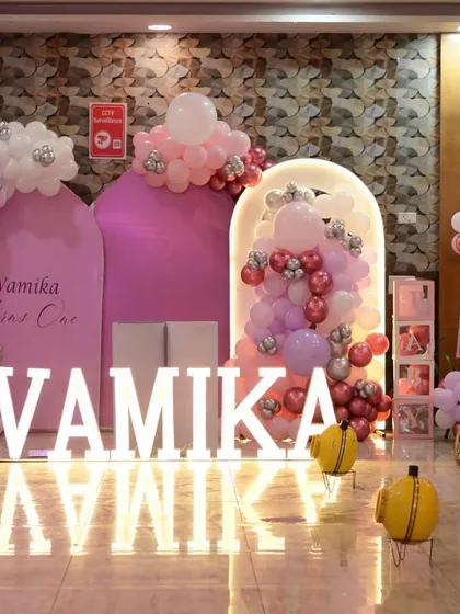 A grand princess party for Vamika's first birthday. This elaborate setup includes multiple arched backdrops, a crescent moon photo prop, and a princess carriage.
