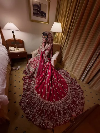 An overhead shot capturing the full glory of the bride's red lehenga with its circular train. A truly show-stopping bridal outfit.