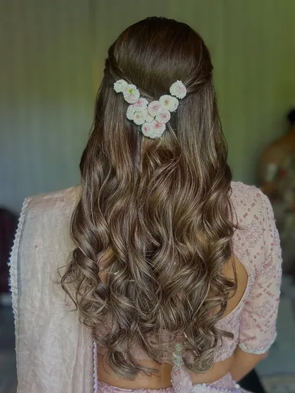 Soft, romantic, and effortlessly chic. This half-up hairstyle with gentle curls is perfect for an engagement or reception. The delicate floral clip adds a touch of elegance without overpowering the look.