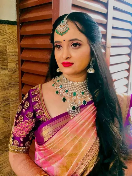 A close up of the bride's makeup for her Varapooje. The look is soft and romantic, with a focus on her eyes and a bright, happy lip color.