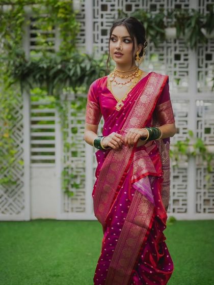 A full view of the bride in her stunning magenta saree. The simple updo allows her beautiful features and the vibrant color of the saree to stand out.
