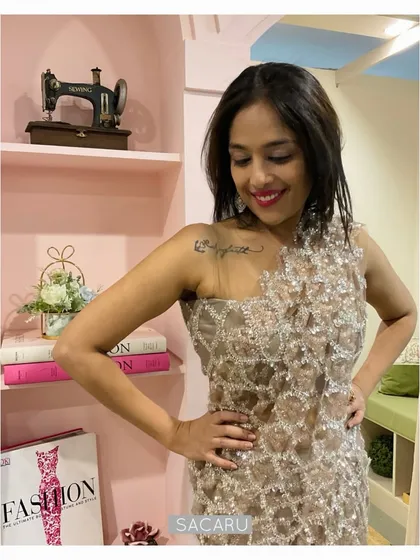 A close-up of the one-shoulder detail of the draped saree dress, crafted from sparkling sequinned tulle.