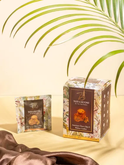 A sophisticated shot of Taste & Beyond cookie packaging, using soft lighting and elegant props like silk fabric. This styling elevates the product, positioning it as a premium snack.