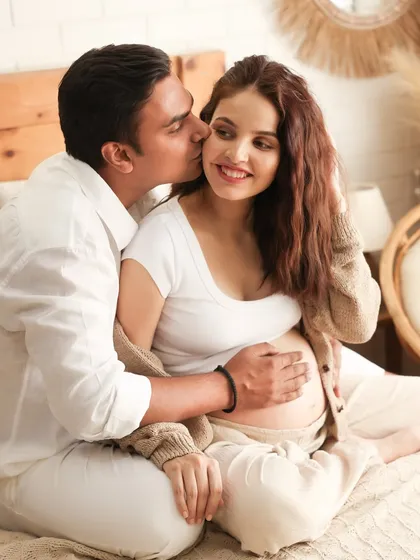 A sweet, candid moment of love. This photo captures the joy and affection between the couple as they prepare to welcome their child.