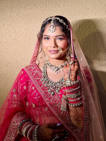 A happy bride enjoying her moment in a beautiful pink lehenga. The matching jewellery completes this perfect rental look.