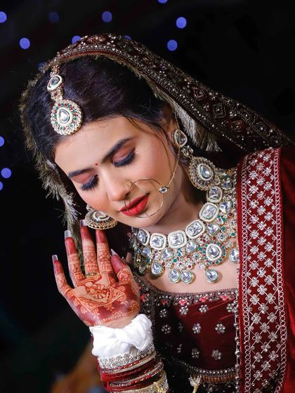 A detailed look at the makeup, showcasing the flawless base and intricate jewelry.