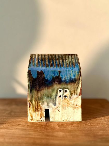 The glaze on this mini house is a stunning mix of blue, brown, and green, showing the beautiful and unpredictable results of high-temperature firing.