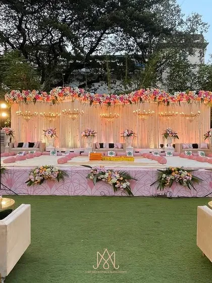 The main stage for the pink-themed Mamera event, featuring a beautiful floral backdrop, elegant chandeliers, and comfortable seating for the family.