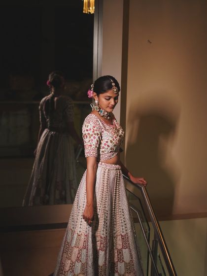Golden hour glow, but make it bridal. This shot captures the bride's elegance and the beautiful details of her lehenga and floral bun.