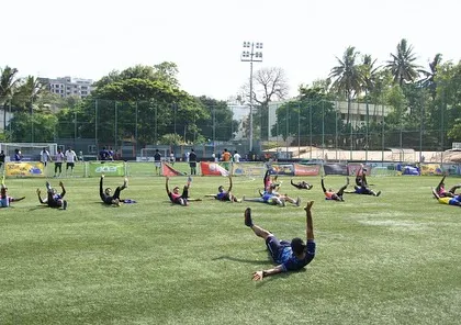 Athletes performing dynamic core and mobility exercises on the field. This is a crucial part of our warm-up protocol to prepare the body for the high-intensity demands of a football training session.