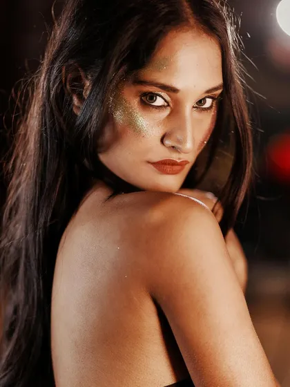 A captivating gaze over the shoulder. The glitter catches the light, and her expression is a mix of confidence and mystery.