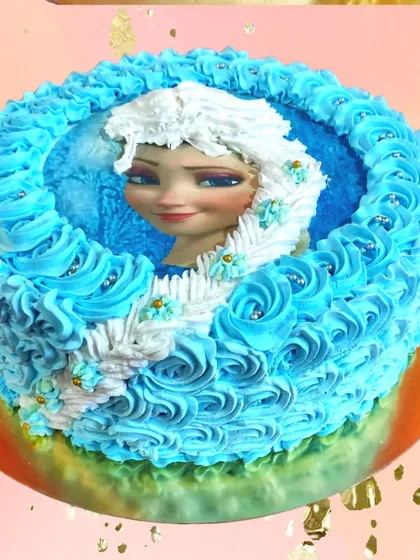 This Elsa cake features a beautiful portrait of the Snow Queen surrounded by intricate blue and white piped rosettes. It’s a dreamy, delicious, and completely fondant-free cake for a Frozen fan.