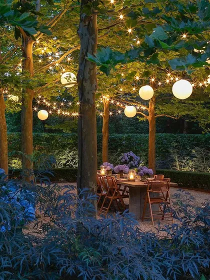 This design creates a magical dining experience nestled within a grove of trees. We used a combination of warm string lights and spherical lanterns to illuminate the space, complementing the natural setting and establishing a romantic, intimate mood for outdoor meals.