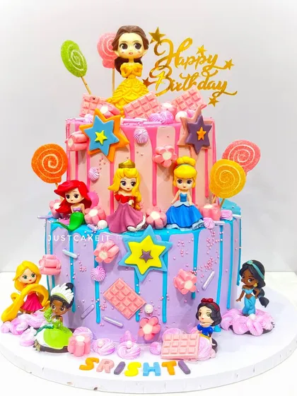 A two-tier Disney princesses cake loaded with characters and candy-colored details. This is a zero-fondant design, using toppers and buttercream.