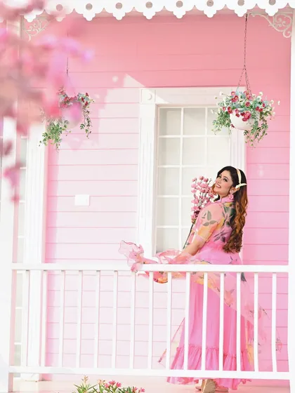 A creative angle of the pink-themed shoot, with blossoms framing the shot. This adds depth and a dreamy quality to the overall composition.