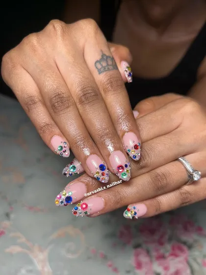 A close-up of the dazzling multi-colored rhinestone nails. I carefully arranged each stone to create a gradient of sparkle on a soft pink base.