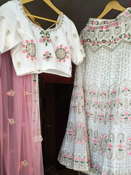 This white lehenga with pink and green floral embroidery is a beautiful and fresh option for daytime events. The complete set is available for rent.
