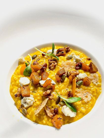 A beautiful vegetarian pumpkin risotto, topped with toasted walnuts, seeds, and crumbled cheese for a variety of textures and flavors.