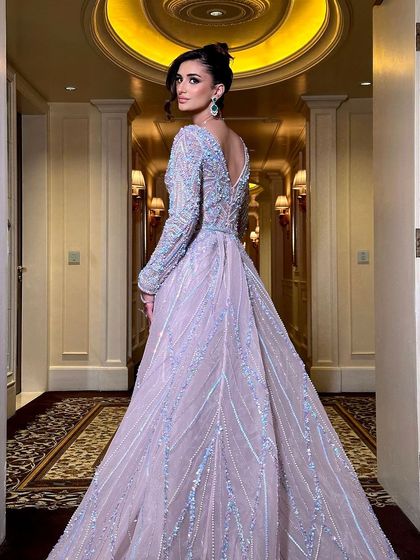 A view from the back, showcasing the dramatic train of the gown and the elegant updo. This look is pure red-carpet glamour, designed for making an unforgettable entrance.