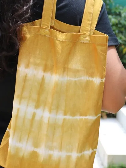 A closer look at the yellow striped tote bag. It's a perfect accessory for a sunny day out.