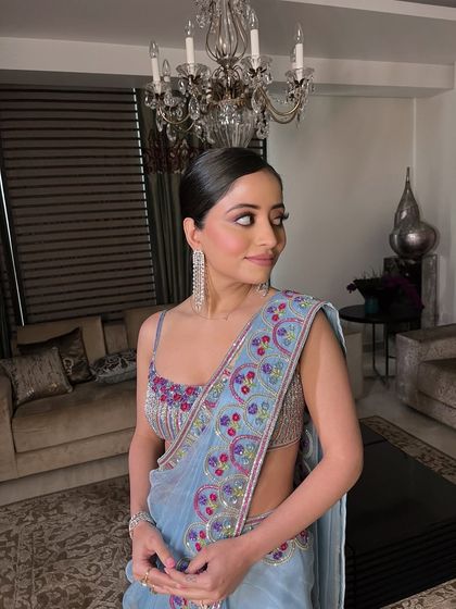 A side profile capturing the elegance of the sleek ponytail and the subtle glow of the makeup.