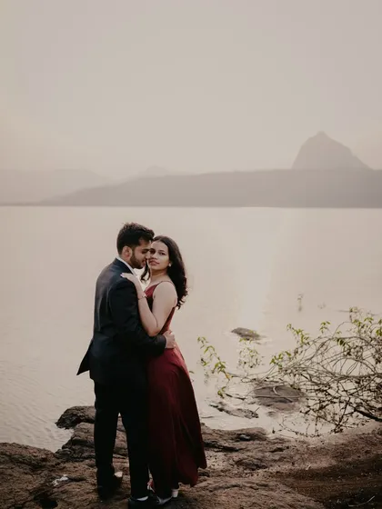 An embrace against the stunning backdrop of a lake at sunset. This photo has a very cinematic and epic feel, perfect for capturing a grand romance.