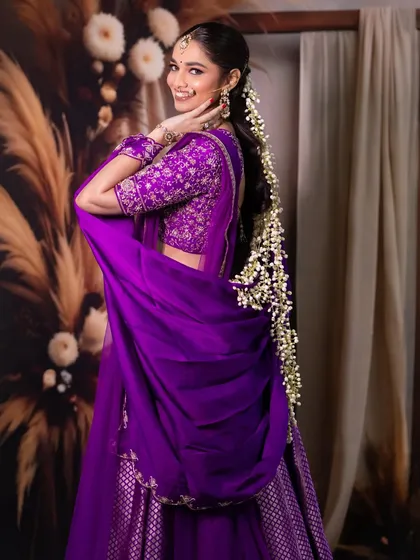 A playful and happy shot, showing the beautiful floral braid and the intricate details of the lehenga.