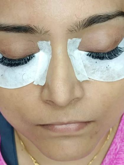 A close-up of the preparation stage. The eye pads are in place to protect the delicate under-eye area and provide a clean canvas for applying the extensions.