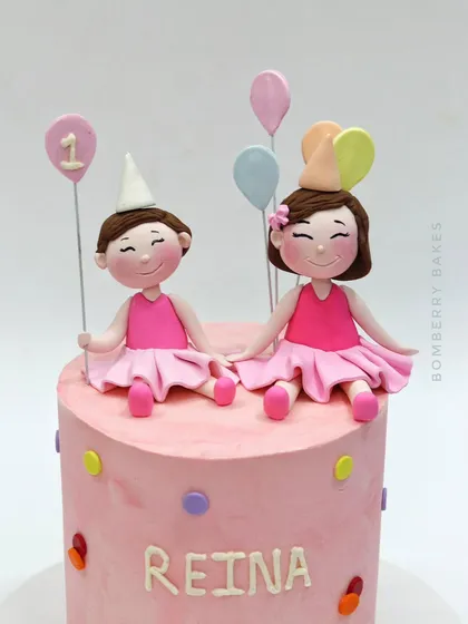 A close-up of the cute, smiling twin girl figurines.