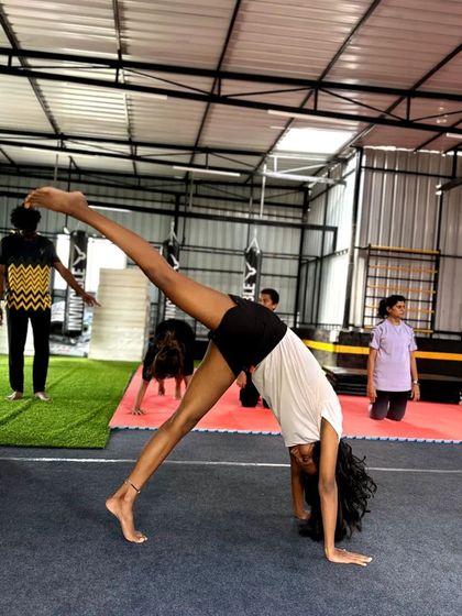 Another angle of a student practicing a one-handed cartwheel, showing her focus and determination.