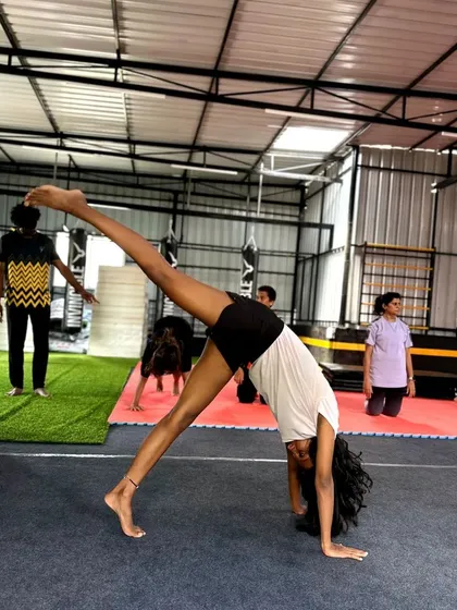 Another angle of a student practicing a one-handed cartwheel, showing her focus and determination.