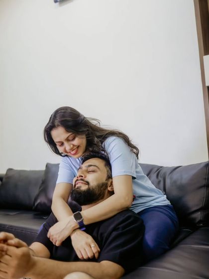 An intimate embrace from behind, capturing a quiet moment of affection in their personal space.