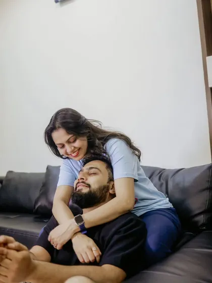An intimate embrace from behind, capturing a quiet moment of affection in their personal space.