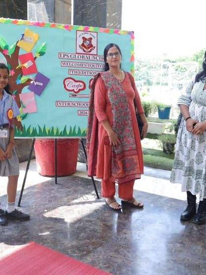 Students and teachers pose at the entrance of our 'Carpe Diem' literary event, standing before a "Wisdom Tree" display. The event celebrates literature and creative expression.