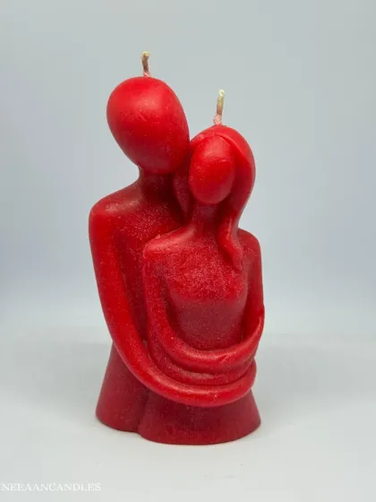 Two flames, one embrace. This red couple candle, showing two figures wrapped in a warm hug, is a beautiful representation of love captured in wax.