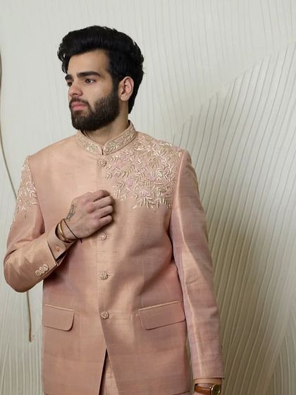 A three-quarter view of the baby pink bandhgala suit, showing its refined fit and the subtle warmth of the minimal threadwork. Perfect for summer weddings.