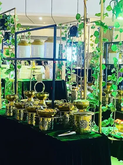 A wide view of the green and gold buffet, showing how I use consistent design elements across multiple stations to create a cohesive and immersive environment for guests.