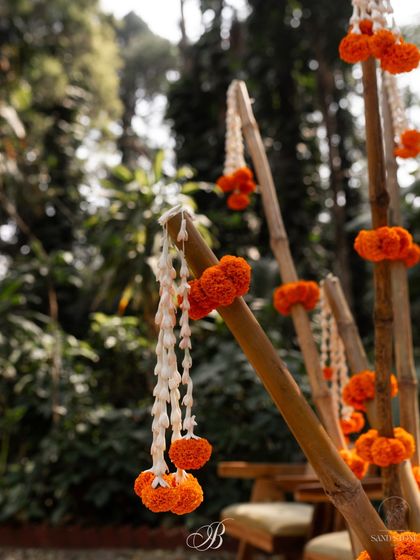 A beautiful detail shot of marigold and tuberose garlands tied to bamboo poles. This simple yet elegant decoration added a touch of tradition and natural beauty to the backdrop.