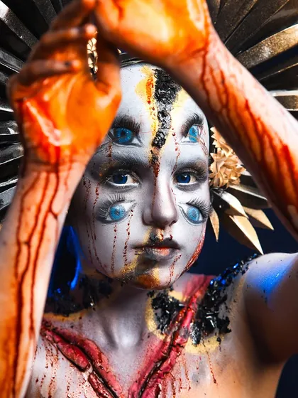 A powerful, confrontational pose that enhances the horror effect of the multi-eyed creature makeup.