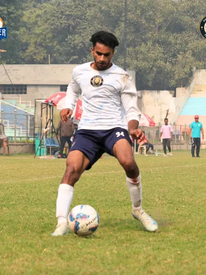 A player shows close control while dribbling, protecting the ball from nearby defenders.