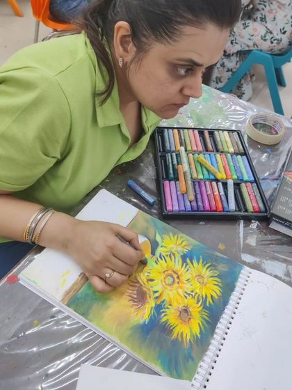 An adult student uses oil pastels to recreate a famous sunflower painting, learning blending techniques for this rich medium.