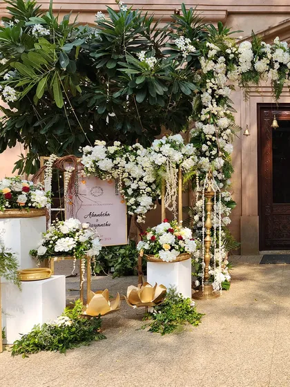 A beautiful entrance setup with an arch of white flowers and hanging pearl strings, creating a look of timeless elegance.