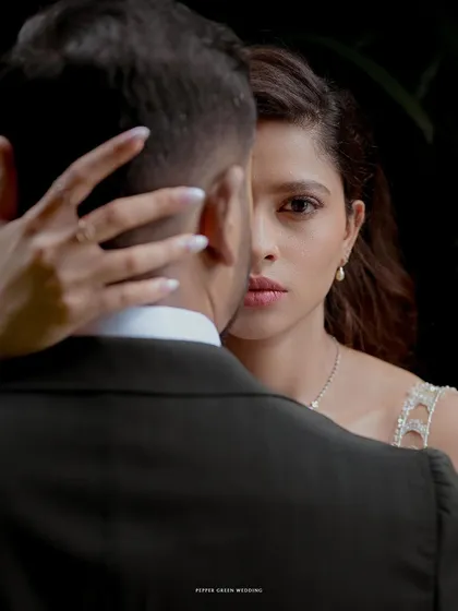 An artistic and intimate portrait of the bride looking over her groom's shoulder. This shot creates a sense of mystery and deep connection.